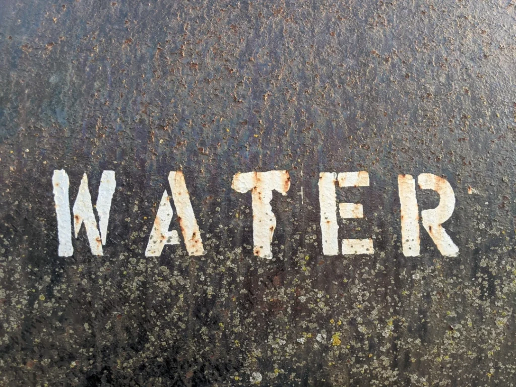 Roughly painted sign saying “Water”